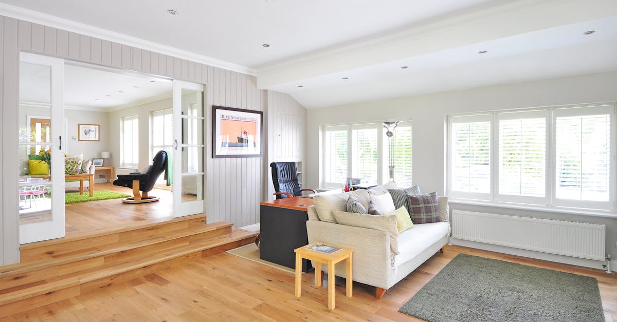 Spacious and bright modern living room with wooden floors and stylish furniture.